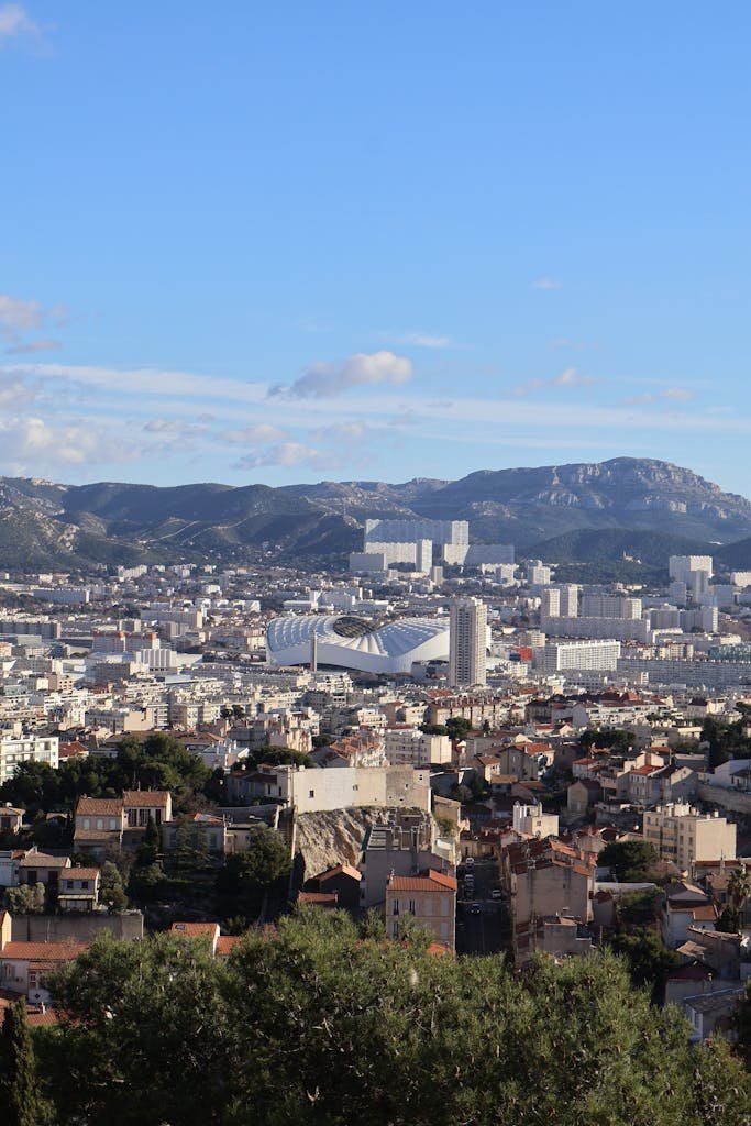 Explore a panoramic view of Marseille, France, with distant mountains under a bright summer sky.